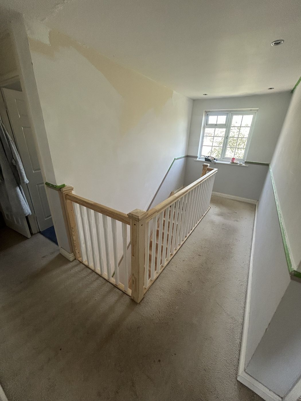 New pine handrail and newel posts with white spindles around a landing