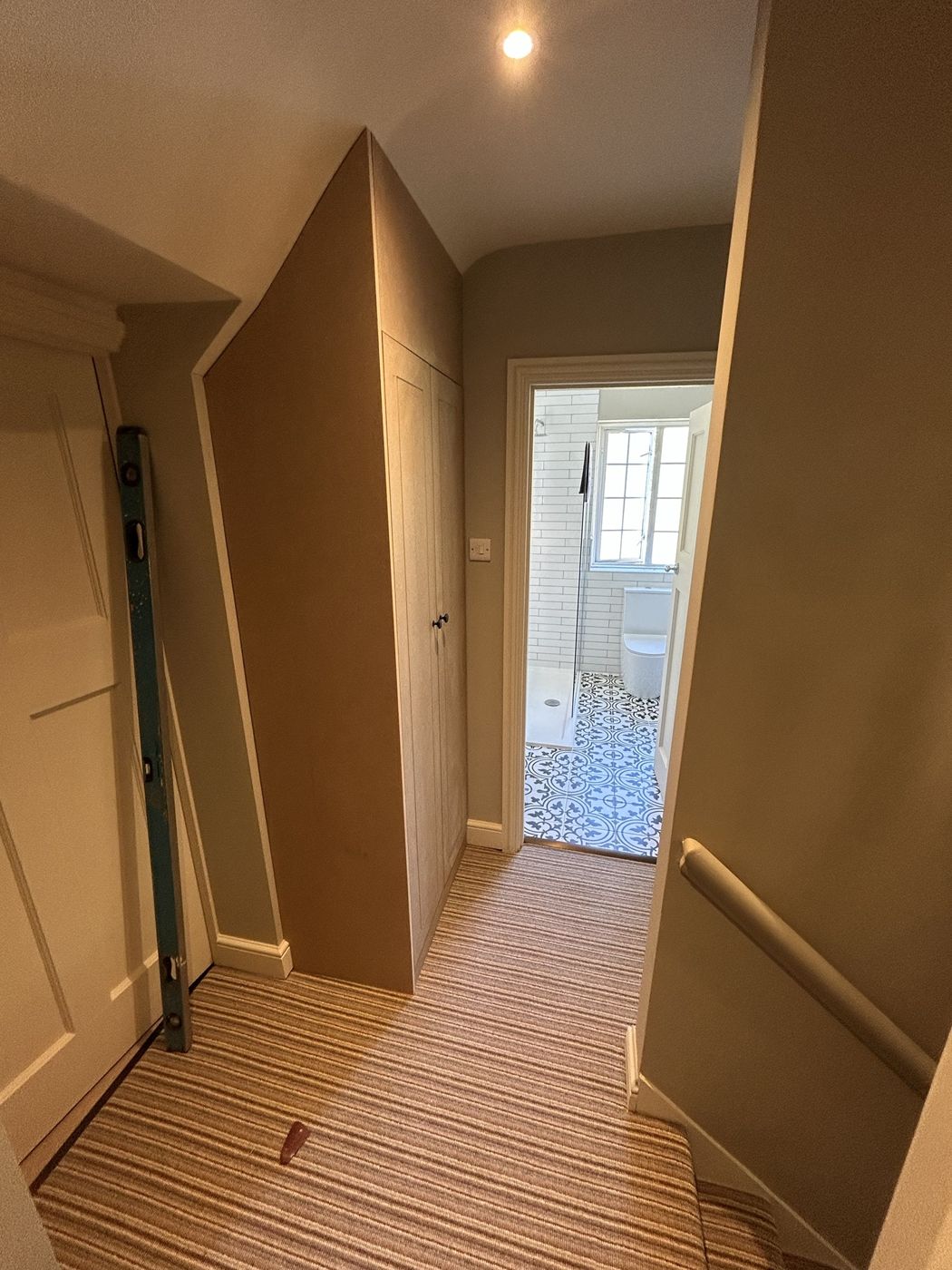 Shaker-style cupboard built under the sloping ceiling on a landing